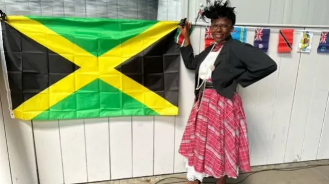 Jennifer poses with the Jamaican flag