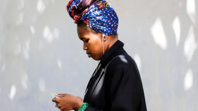 A woman looking at her phone in Nairobi, Kenya