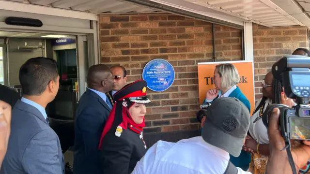 A circular blue plaque is unveiled by Tilbury docks