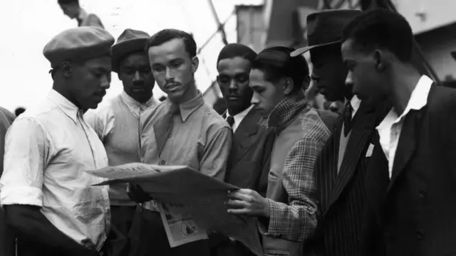 Immigrants on board the Empire Windrush reading a newspaper