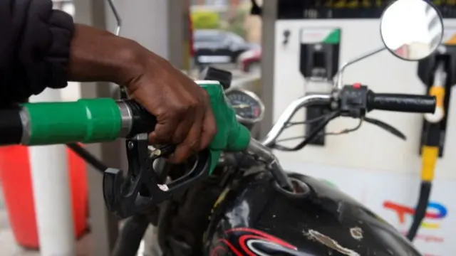 A worker fills the tank of a motorcycle at a petrol station in Nairobi, Kenya -  May 2023