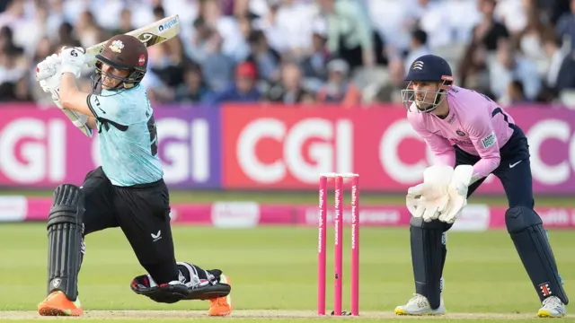 Surrey's Sam Curran batting and Middlesex's Joe Simpson keeping wicket