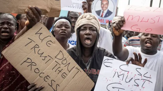 Hundreds of supporters of the opposition party, All People's Congress (APC), hold up signs calling for the Chief electoral Commissioner, Mohamed Konneh, to step down after allegations of electoral fraud, at a protest in Freetown - 21 June 2023