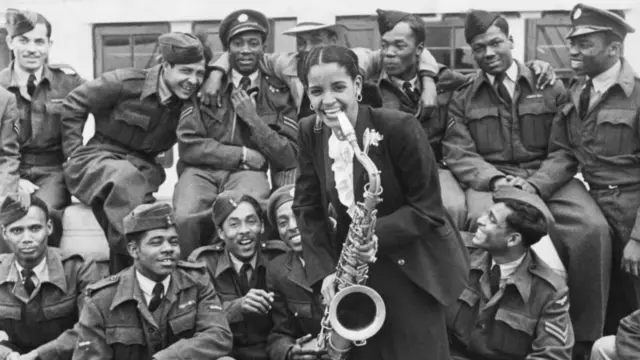 Mona Baptiste, a blues singer, on board the Empire Windrush holding a saxophone