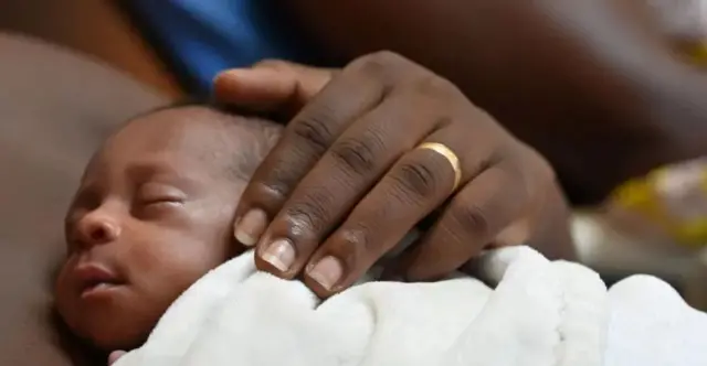 new-born baby in mother's arms