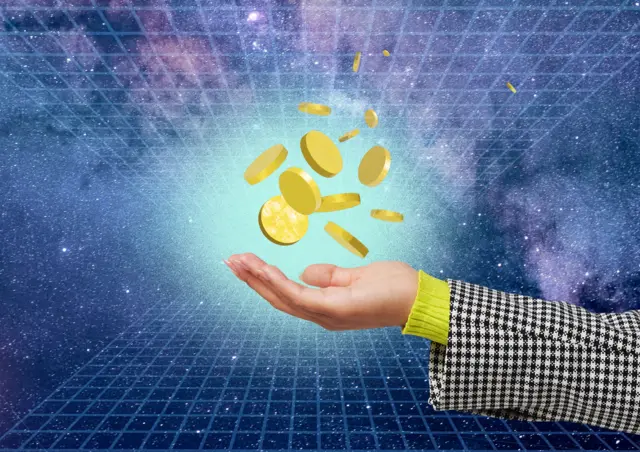 A collection of gold coins hove above a human hand in a virtual space (stock photo)