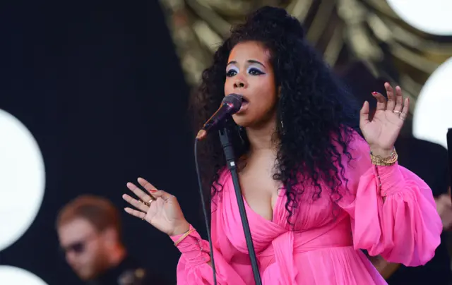 Kelis singing in a pink dress on the Pyramid stage