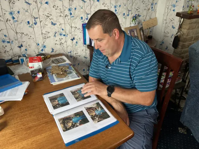 Peter Bailey looking through a photo album