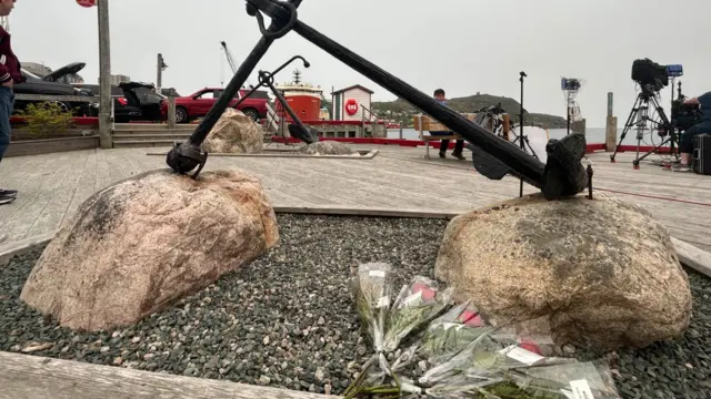 Floral tributes lie in the port of St John