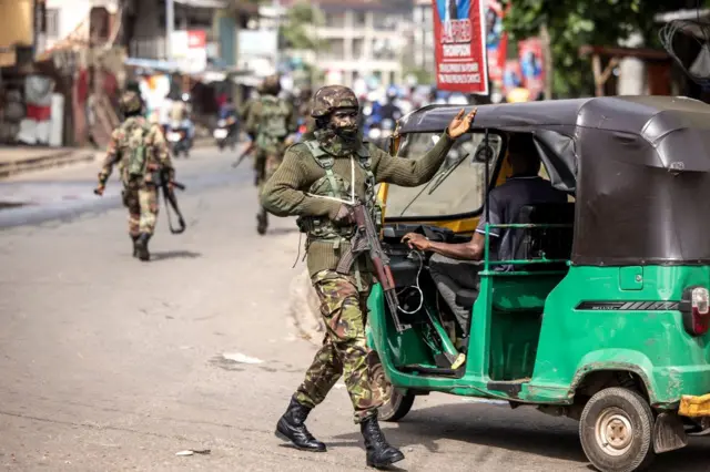 A soldier of the Sierra Leone Armed Forces directs traffic after supporters of the opposition party, All People's Congress (APC) clash with police during a protest calling for the Chief electoral Commissioner, Mohamed Konneh, to step down after allegations of electoral fraud in Freetown on June 21, 2023.