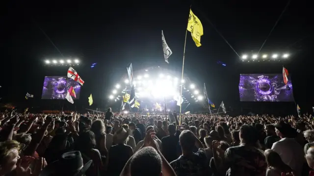 Crowds watch Guns N' Roses performing on the Pyramid Stage at the Glastonbury Festival