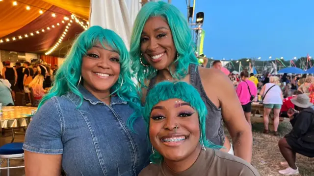 Three members of Lizzo’s backing band pose for a photo