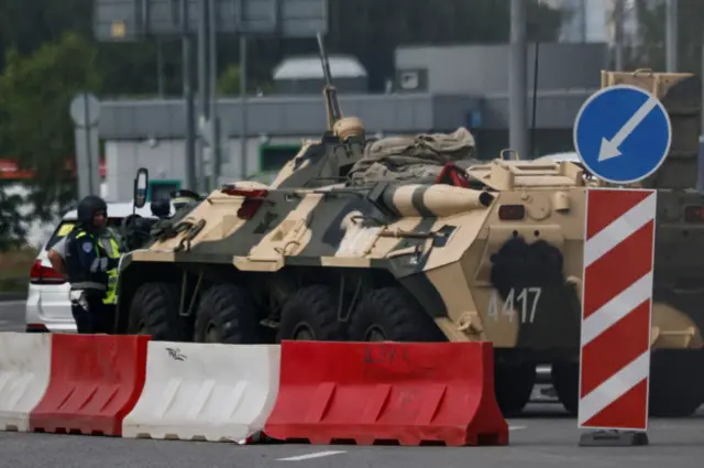 A police officer checks a car next to an armoured personnel carrier in Moscow