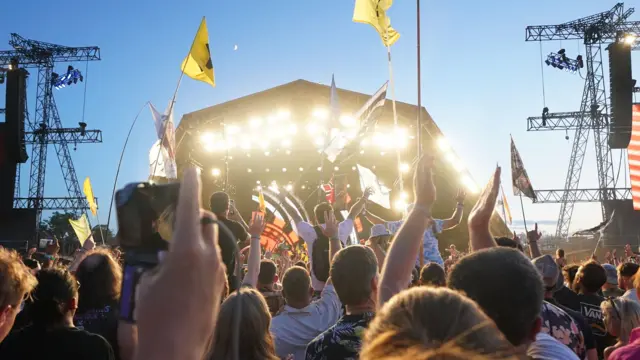 Crowds watch Guns N' Roses performing on the Pyramid Stage