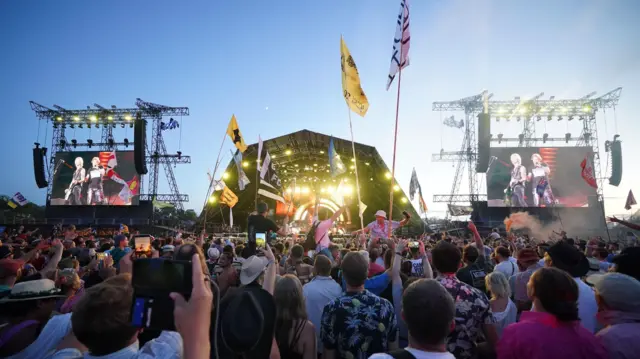 Crowds watch Guns N' Roses performing on the Pyramid Stage at the Glastonbury Festival