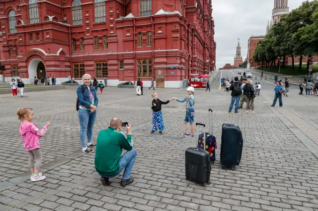 Children have their photo taken near the Kremlin while Red Square is closed