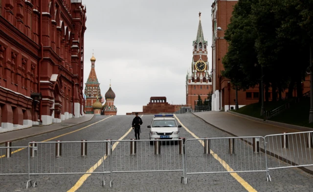 Police guard an empty Red Square behind a fence of barricades on Saturday 24 June