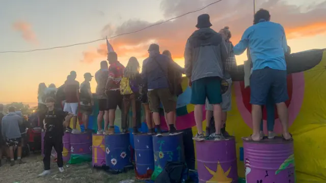 People turning bins upside down to get a better view of Elton