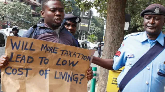 Kenyan police officers detain a Kenyan social-political activist during a protest to call on lawmakers to reject the finance bill proposed by the government that would raise various taxes, outside the Parliament Buildings in Nairobi, Kenya June 13, 2023