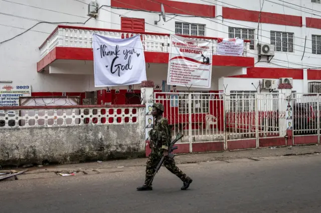 A soldier of the Sierra Leonean Armed Forces walks past the opposition party, All People's Congress (APC) headquarters in Freetown on June 26, 2023.