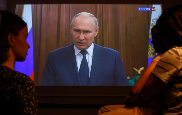 A family watches Russian President Vladimir Putin's video address to the Nation in Moscow, Russia, 26 June 2023.