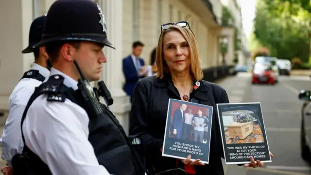 Lorelei King holds up photos of her husband