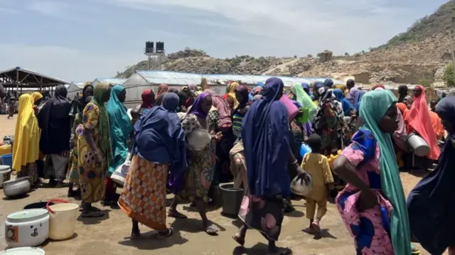 People wait to fill buckets with clean water from a water well at the Gwoza IDP Camp in Borno State, Nigeria - 3 May 2023