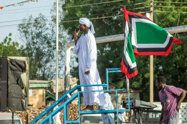 An imam gives a sermon before Muslim worshippers during the morning prayers for Eid al-Adha in Wad Madani - 28 June 2023