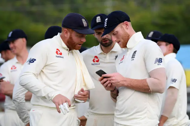 Jonny Bairstow and Ben Stokes looking at a mobile phone