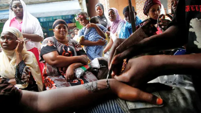 Muslim women wait for their turn to get henna tattoos a day ahead of Eid al-Adha, in Adjame Abidjan, Ivory Coast - 27 June 2023
