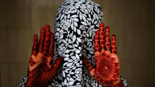 A Muslim woman shows her hands with henna tattoos a day ahead of Eid al-Adha, in Adjame, Abidjan, Ivory Coast June 27, 2023