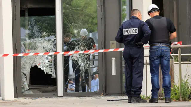 Police next to a smash window