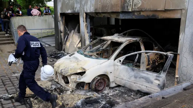 Police man near burnt car