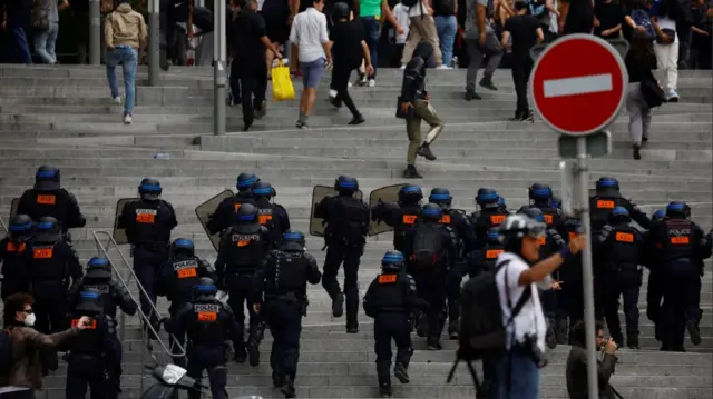 French riot police react amid clashes with protesters during a march