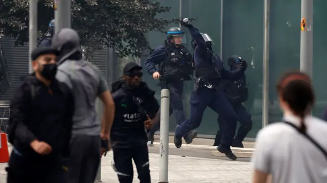 French riot police throw tear gas at protesters during a march in memory of Nahel