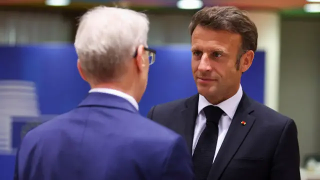 Emmanuel Macron in conversation at the EU leaders summit in Brussels