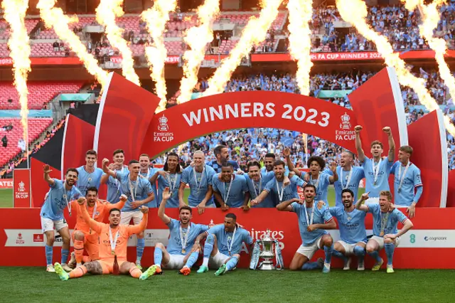 The Manchester City squad celebrate under the 'winners' arch