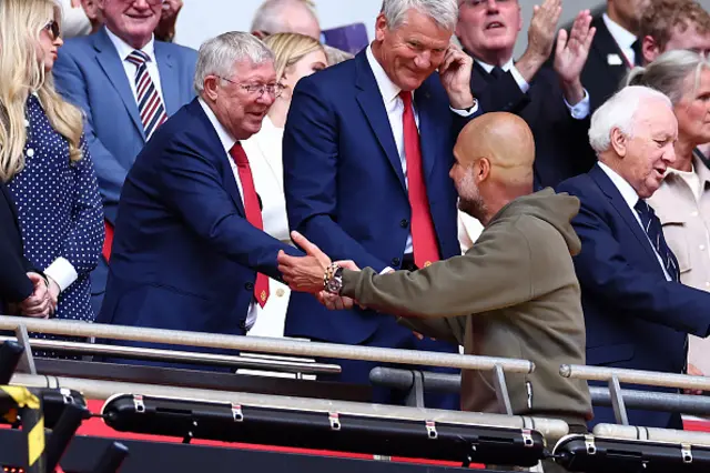 Sir Alex and Pep shake hands in the stands