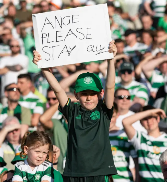 Boy holding sign asking Postecoglou to stay