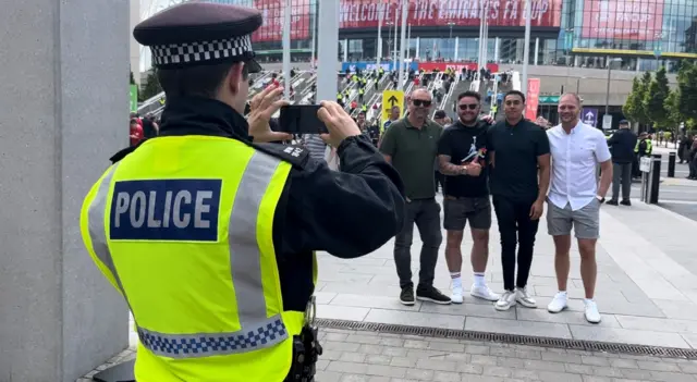 Police takes a photo of fans