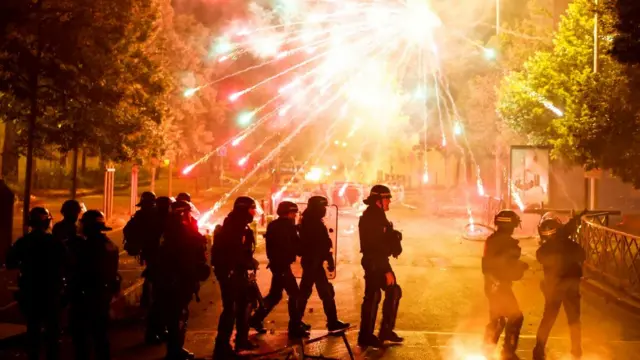 French police stand in position as fireworks go off during clashes with youth in Nanterre, Paris suburb, France, June 30, 2023.