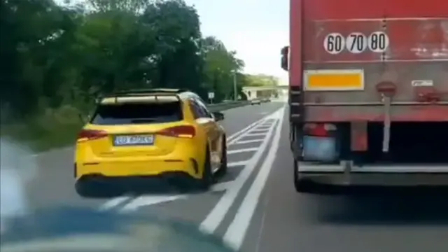 Still of car passing lorry on road