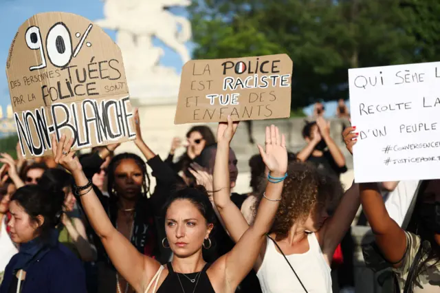 People hold up placards during a demonstration in Paris