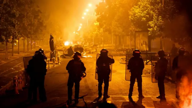 French police stand in position during clashes with protesters