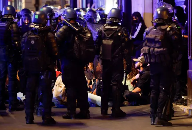 Riot police stand guard at a protest near the Opera Garnier