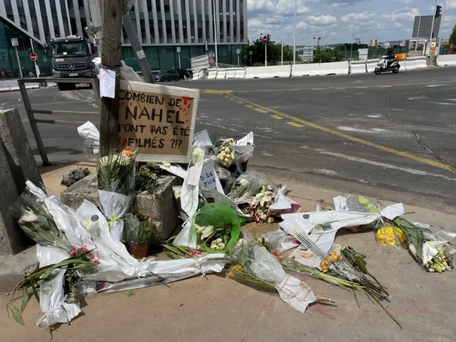 Flowers laid in Nanterre against a signport