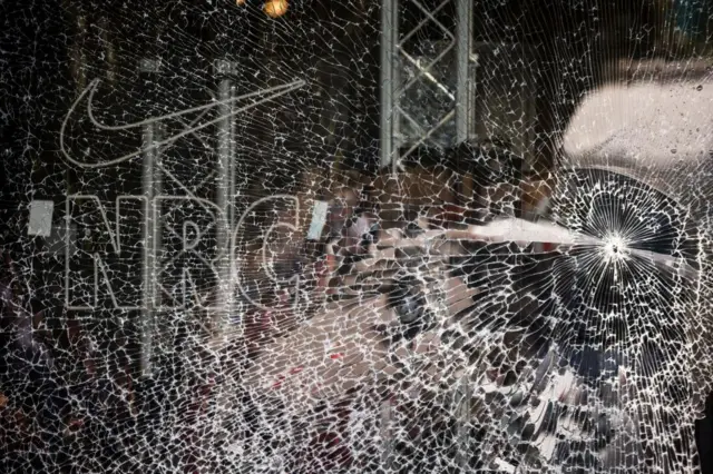 A broken Nike store front window following riots in Paris, France, 30 June 2023