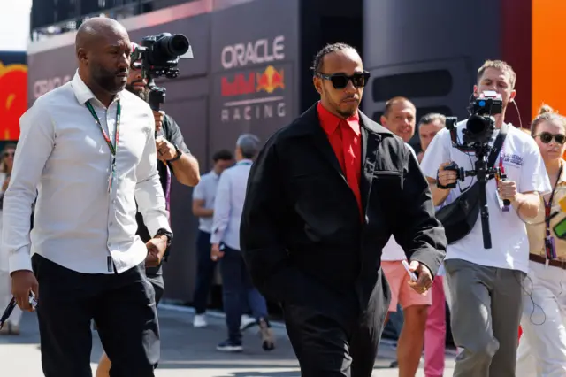 Lewis Hamilton arrives in the paddock in Barcelona