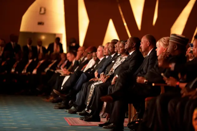 People sit in a row, including Namibia's first lady and the Ivorian president