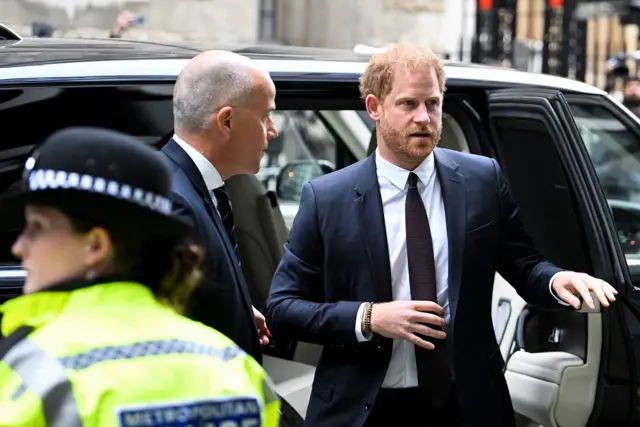 Harry leaves his car as he arrives at the High Court